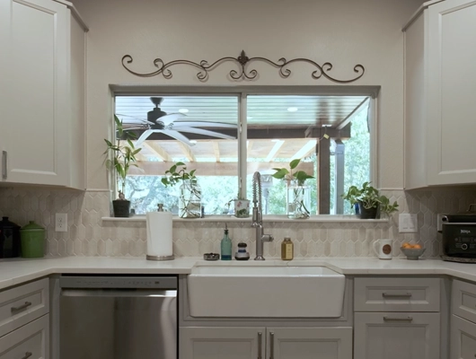 shot of a white kitchen sink with gray cabinets