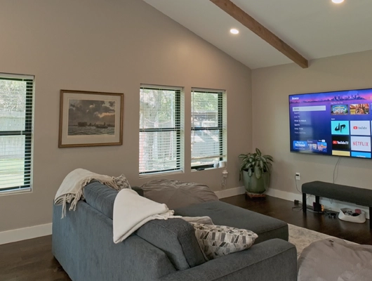 family game room addition with a gray couch and flat screen tv