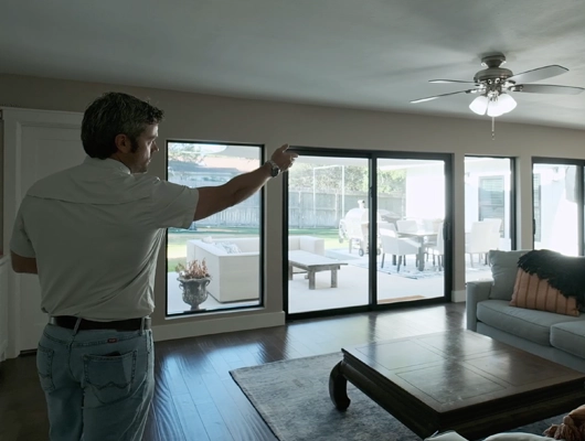 man standing in living room pointing towards the right