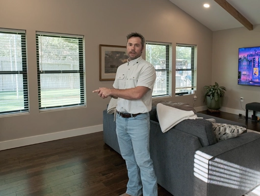 man standing in a bonus room pointing to the left