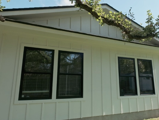 White House with black trim and a tree branch
