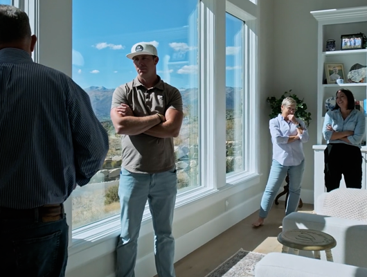 Brennan and Kelsie Conner speaking with clients inside a custom built home in Utah county, Utah