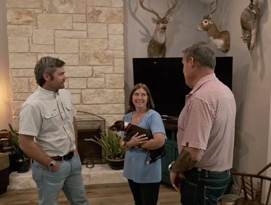 remodeler talking with two clients in a remodeled living room