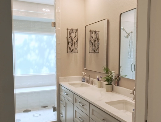 Master bathroom with white countertops and sage green cabinets