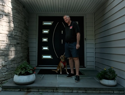 John Petsco standing on the porch of a remodeled home in Port Jefferson, NY