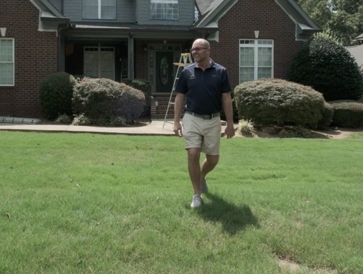 man walking through grass while looking to the left