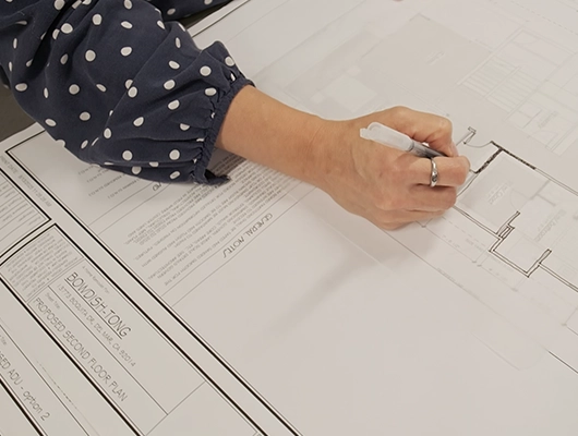 woman architect sketching on plans