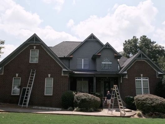 dark and moody exterior of a house with guys working on the outside