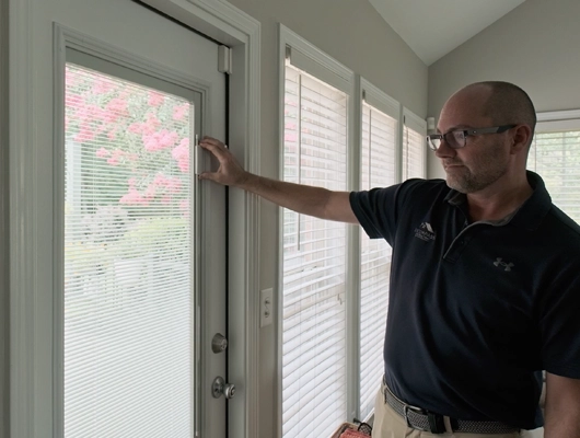 remodeler inspecting the blinds on a back door