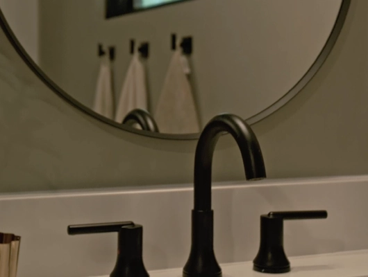 black sink bathroom faucet with mirror showing three towels