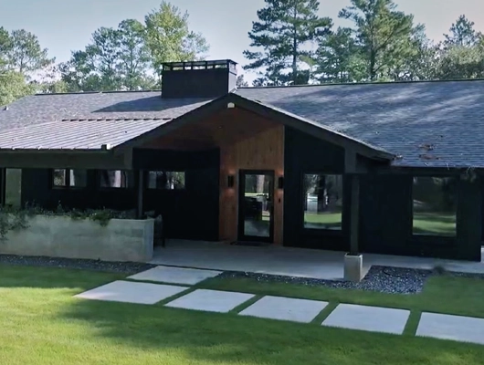 modern ranch style house with green grass and square path stones