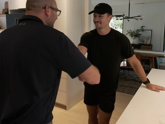 tow men shaking hands in a kitchen
