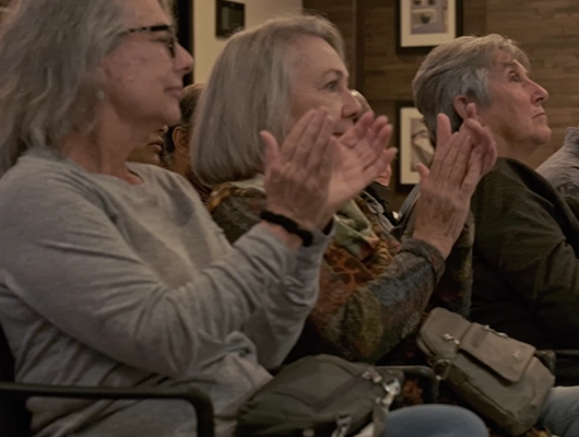 two women in audience clapping