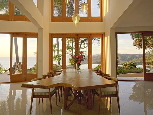 large teak dining table overlooking ocean view